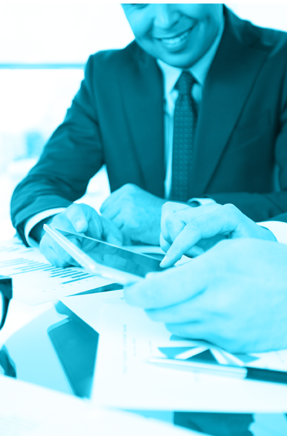 Ejecutivo revisando información en una tableta junto a documentos de trabajo